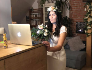 A woman standing in front of a laptop computer.